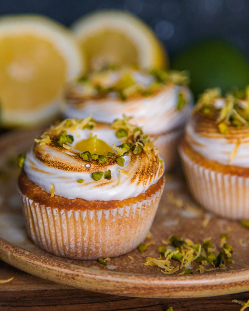 vegane Zitronen Cupcakes mit einer Füllung aus Lemon Curd. Dekoriert mit flambiertem Baiser. Ideal für Ostern