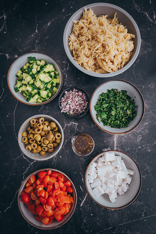 veganer Orzo Salat, griechisch und mediterran. Mit Orzo Nudeln, Tomaten, Oliven, Gurke und veganem Feta