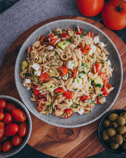 veganer Orzo Salat, griechisch und mediterran. Mit Orzo Nudeln, Tomaten, Oliven, Gurke und veganem Feta