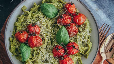 Spinat Tagliatelle in einer Soße aus Avocado und Basilikum, dazu geschmorte Cherrytomaten, vegan