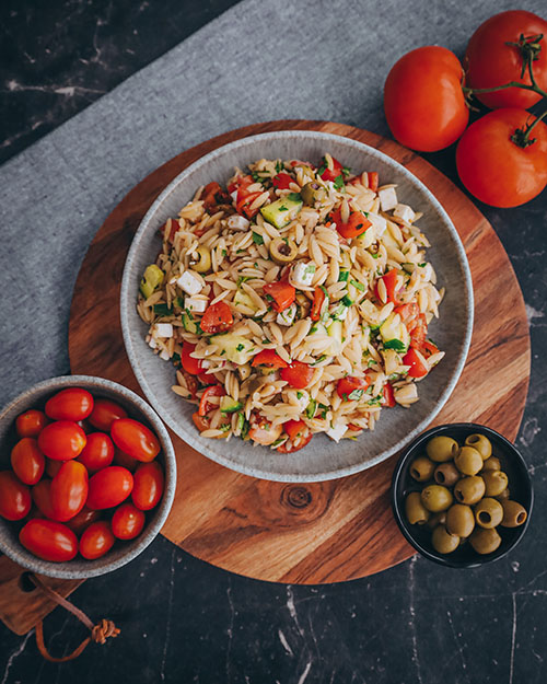 veganer Orzo Salat, griechisch und mediterran. Mit Orzo Nudeln, Tomaten, Oliven, Gurke und veganem Feta